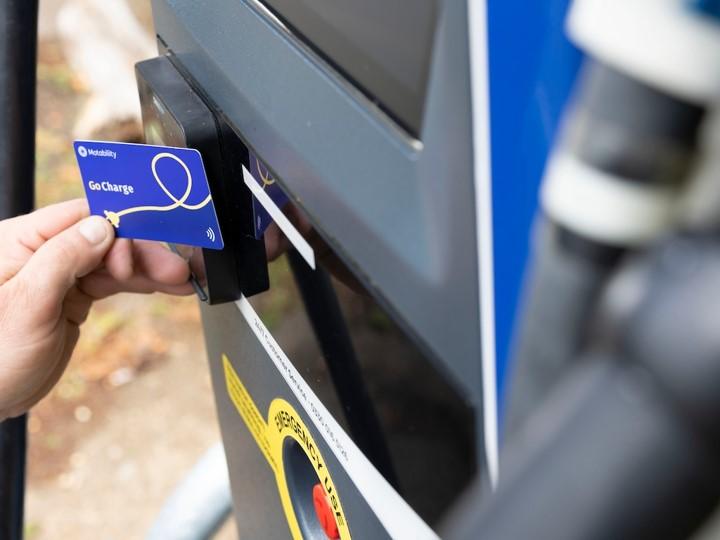 Image of a card being tapped against charging station for payment